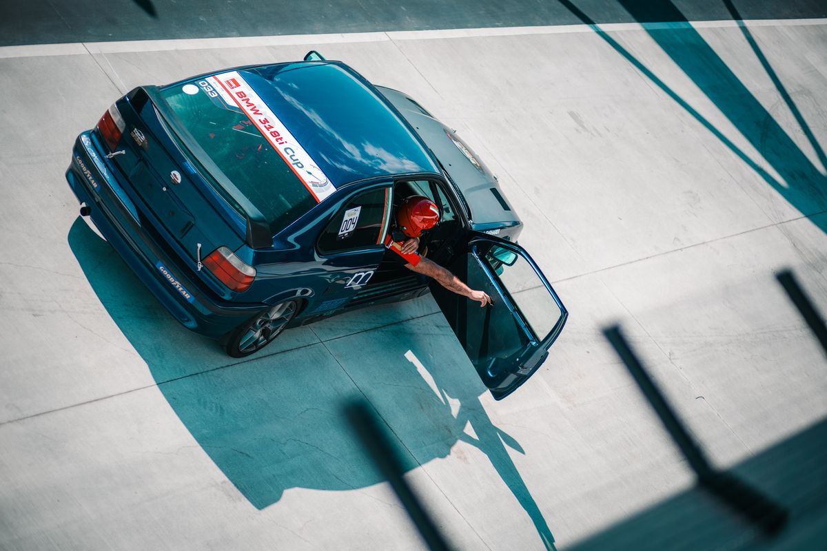 Driver climbing out of a race car, shot from above