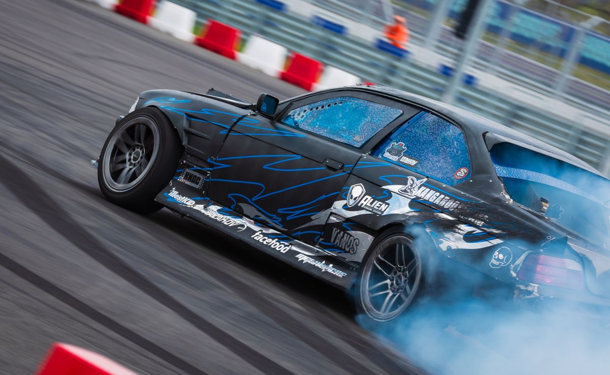 Drift car sliding sideways in a cloud of tyre smoke